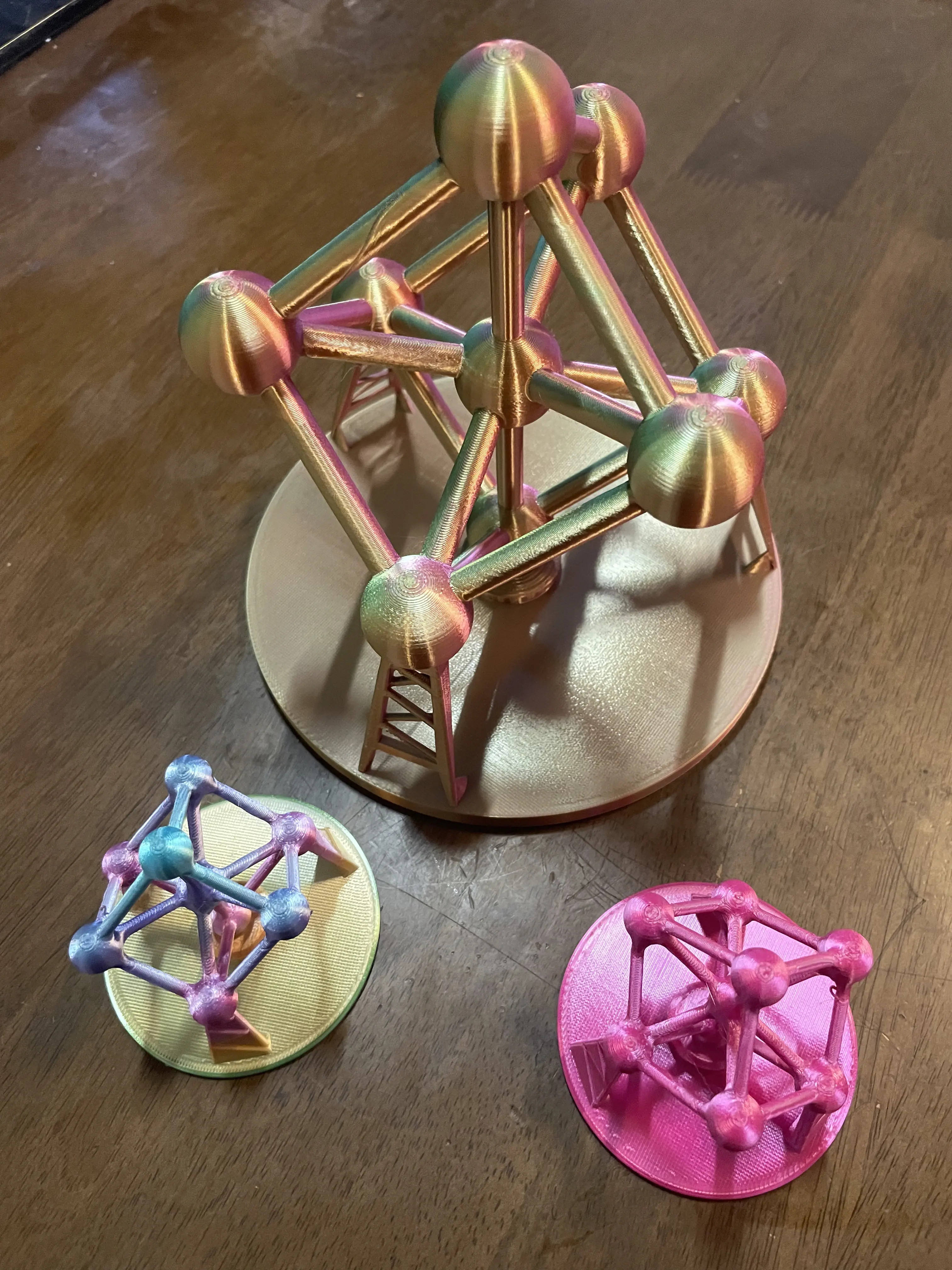 Multicolor 3D printed Atomium sculptures displayed on a wooden table