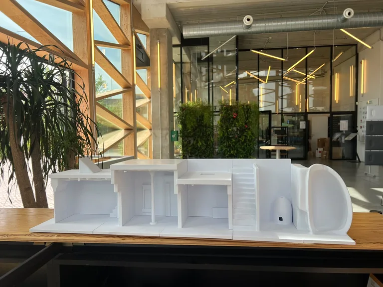 White 3D printed architectural scale model of a building interior cross-section with rooms and staircase, made by MadeInBXL in Brussels